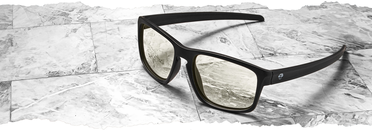 Marcos y armazones ópticos en plástico reciclado Bonoboss. Lentes ópticos de moda de color negro sobre fondo marmoleado con lentes filtro azul con receta oftalmológica.