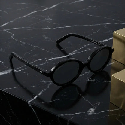 Lentes sol Guapi Island polarizados UV400 bio-acetato negro sobre marmol negro superficie premium elegante Bonoboss #editorial_polarizado #color_negro