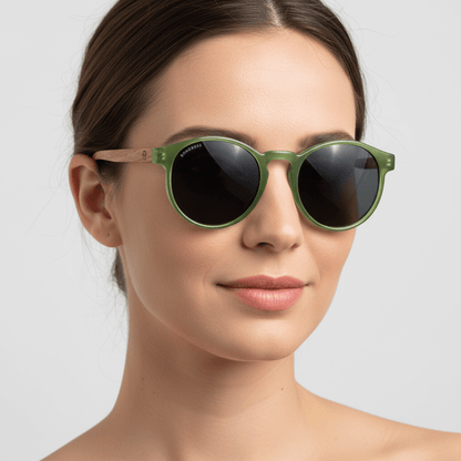 vista lateral de una modelo mujer de cara redonda usando unos anteojos anteojos gafas de sol polarizadas de forma redonda y con puente para narices anchas hechas de plastico reciclado sustentable ecologico personalizada y patas de madera de #color_verde