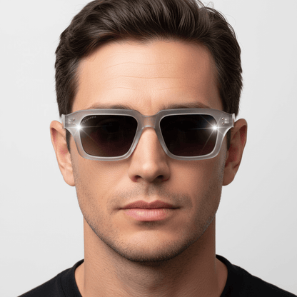 la vista frontal de un modelo hombre de forma de cara redonda usando unos anteojos gafas de sol polarizadas de plastico reciclado sustentable personalizada para regalo corporativo de #color_gray