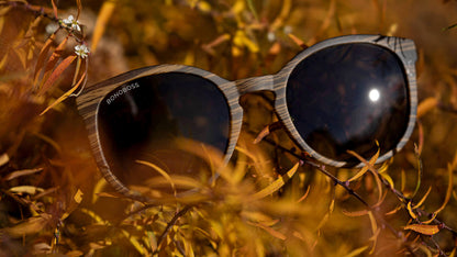 anteojos redondos de plástico reciclado y varillas de madera natural sustentable con lentes de color negro polarizadas y forma redonda.  #color_negro