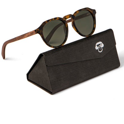 anteojo de sol polarizado hexagonal de color carey con lentes verdes o g15 sobre un estuche #color-marco_carey