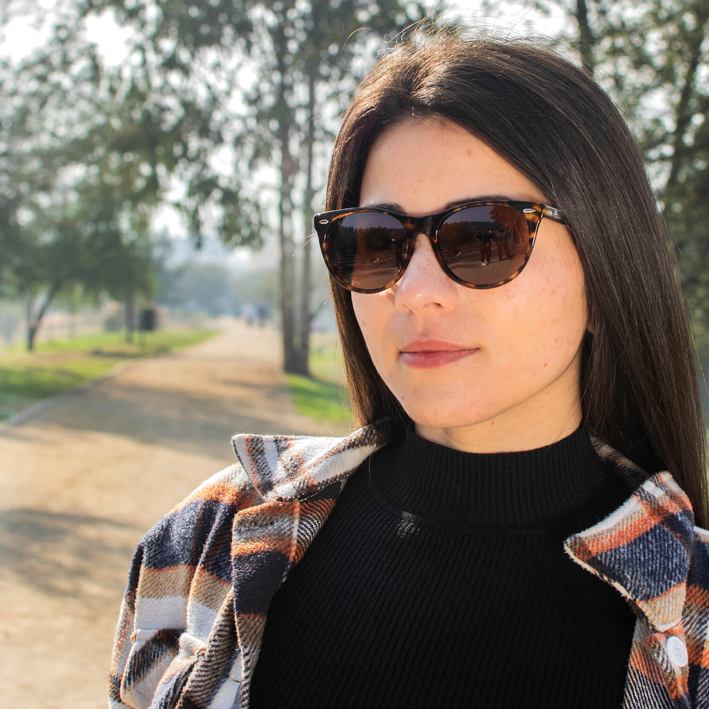 mujer de cara redonda grande usando lentes agatados de sol polarizados