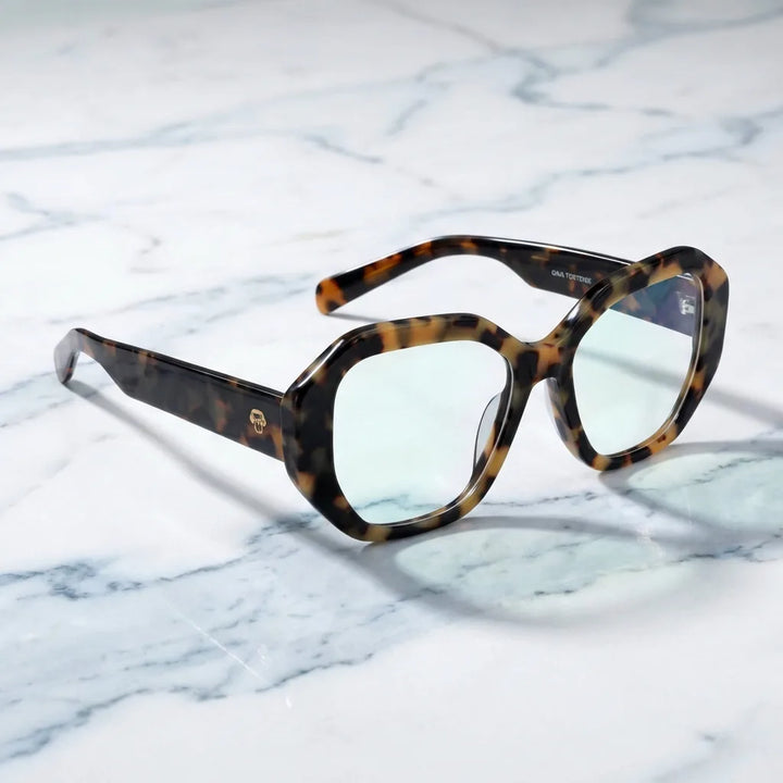 Anteojos Gaia color carey (bio-acetato geométrico), sobre una superficie de mármol #editorial_armazon #color_carey