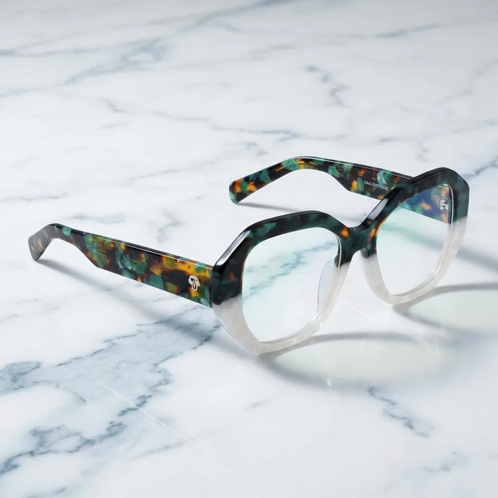 Armazón de lentes Gaia en verde: sobre una superficie de mármol, bio-acetato geométrico #editorial_armazon #color_green