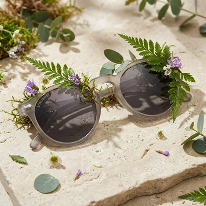 Lentes sol Temuco polarizados RPET reciclado del oceano gris sobre follaje botanico detalle lente natural Bonoboss #editorial_grid2 #color_gris